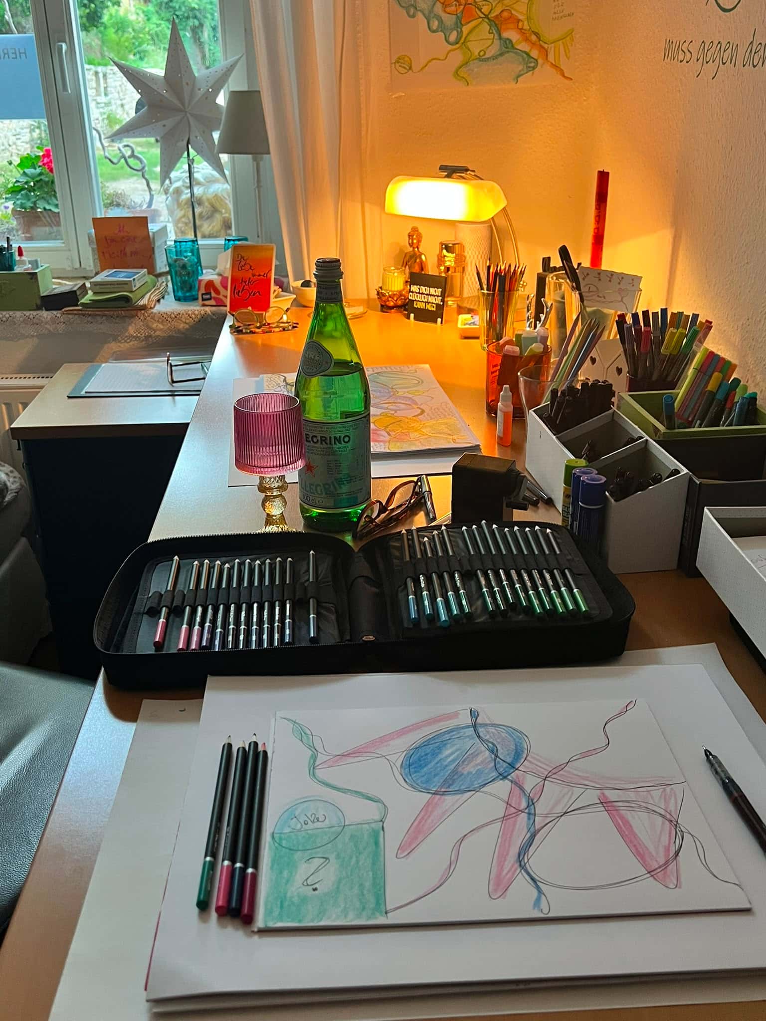 Atelier von Sarah Croé — Schreibtisch mit neurographischer Zeichnung, Stiften und warmem Licht am Fenster